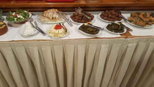 een tafel met veel verschillende soorten voedsel erop bij Hotel Adonis in Mithimna