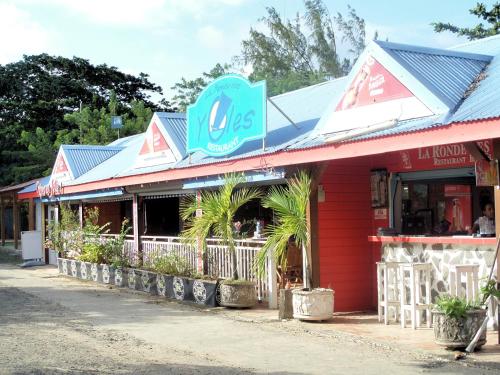a red building with a sign on top of it at Caraïbes Holidays in Sainte-Anne