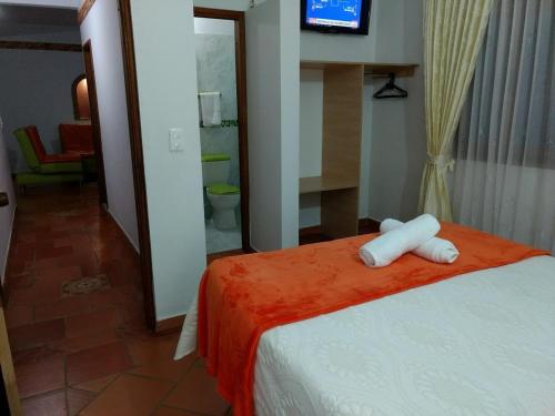 a bedroom with a bed with white towels on it at Apartahotel La Gran Familia in Villa de Leyva
