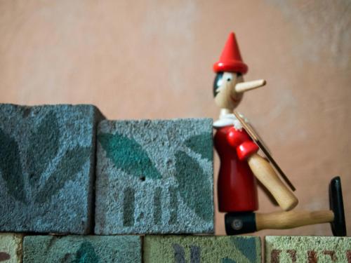 a toy figurine of a person on a brick wall at La Luna nel Pozzo in Parma