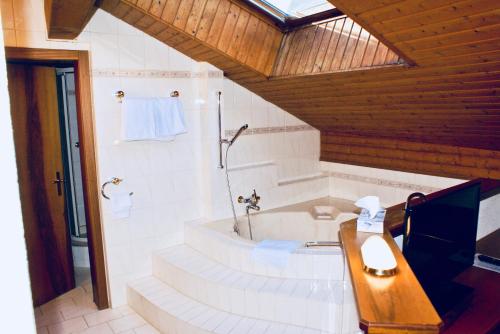 a bathroom with a bath tub and a sink at Hotel du Pont in Brig