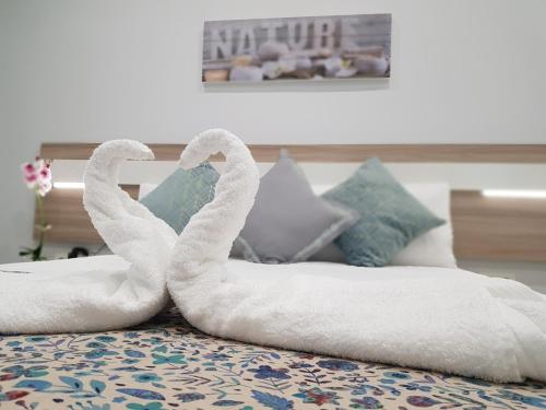 two towel swans sitting on top of a bed at Apartamento Capuchinos Cordoba in Córdoba