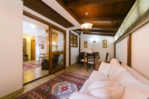 ein Wohnzimmer mit einem Sofa und einem Esszimmer in der Unterkunft Suítes Belvedere - Apto Individual in Gramado