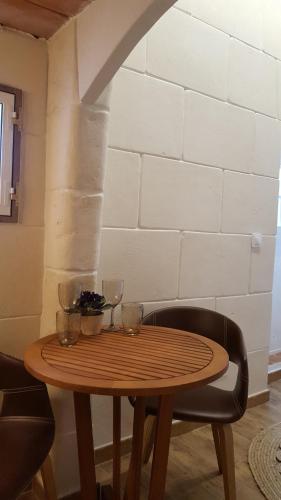 a wooden table with wine glasses on top of it at Habitaciones Casa de Campo Daymipaz in Mahón