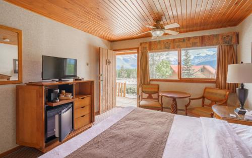 a bedroom with a bed and a flat screen tv at The Crossing in Saskatchewan River Crossing