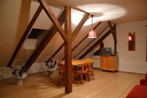 a dining room with a wooden table in a attic at Residenze Sonnenschein Casa Rosa in Villabassa
