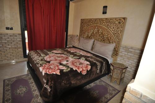 sypialnia z łóżkiem z kwiatami w obiekcie Babylon Appartments w Marakeszu