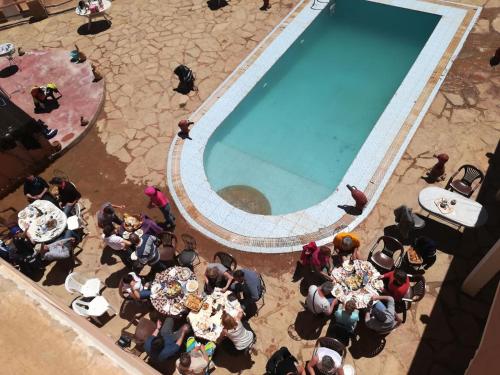 a group of people standing around a swimming pool at Auberge Camping BOUGAFER Tamtetoucht in Tamtetoucht