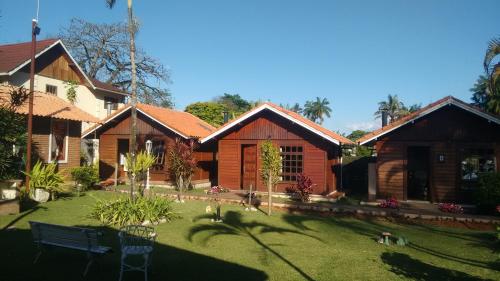 a house with a grass yard in front of it at Pousada Mon Desir in Penedo