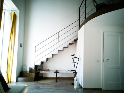 een witte kamer met een trap en een tafel bij casa vacanza il sole di Napoli in Napels