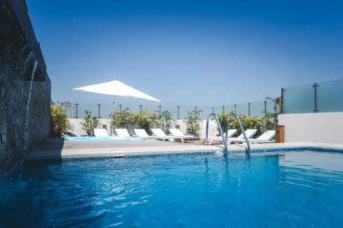 una piscina con tumbonas en un complejo en Costa del Sol Wyndham Piura, en Piura