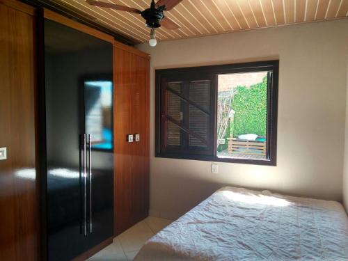 a bedroom with a bed and a window at Casa para temporada in Capão da Canoa