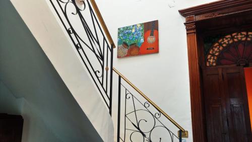 a stairway with a painting on the wall next to a stair case at Viva Merida Hotel Boutique in Mérida