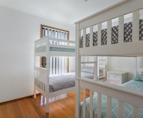 a room with two bunk beds and a bed at Breakaway on Niblick: newly renovated in Rye