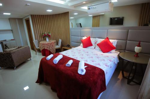 a hotel room with a large bed with red pillows at Piloes Palace Hotel in Mineiros