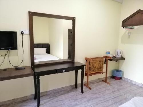 a mirror on a desk in a room at Motel Seri Mutiara in Kuah