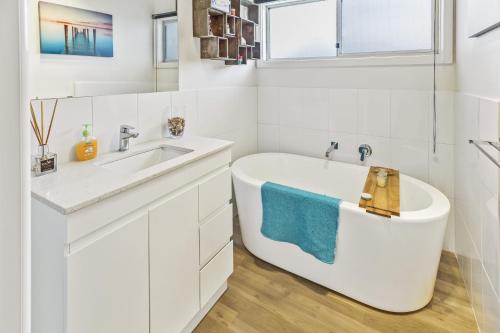 a white bathroom with a tub and a sink at Tanjil in Paynesville
