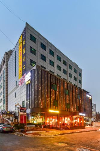 a large building with glass windows on a street at Hotel Ritz in Suwon