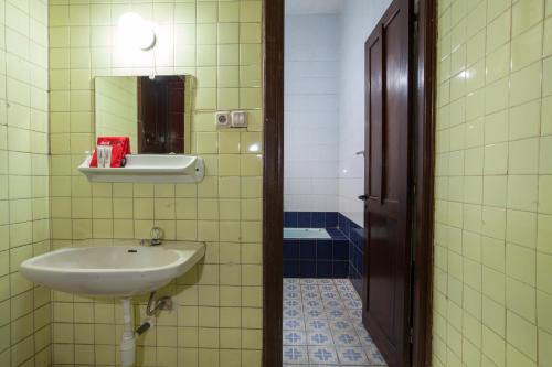 a bathroom with a sink and a mirror at RedDoorz near Balai Kota Malang in Malang