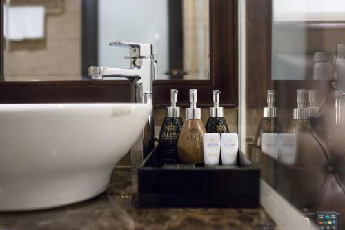 a bathroom with a sink and bottles of soap at Alisa Hotel & Spa in Hanoi