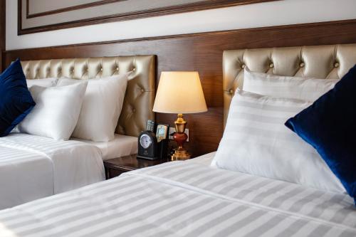 a bedroom with two beds and a lamp on a table at Alisa Hotel & Spa in Hanoi