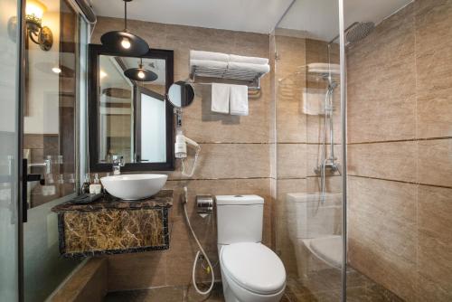 a bathroom with a toilet and a sink and a mirror at Alisa Hotel & Spa in Hanoi