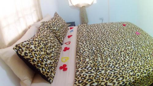a bed with a leopard print sheets and pillows at Caribbean Dream Vacation Property CD2 in Rodney Bay Village