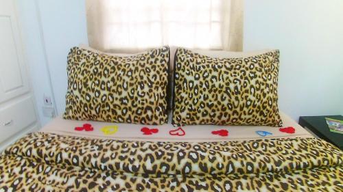 a bed with two pillows on top of it at Caribbean Dream Vacation Property CD2 in Rodney Bay Village