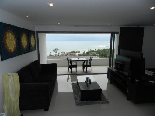 a living room with a couch and a table at Tropical Sea View Residence in Lamai