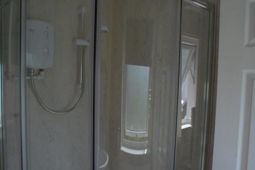 a shower with a glass door in a bathroom at The Haldon Guest House in Paignton
