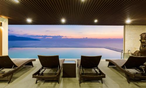 a room with two chairs and a swimming pool at Balcona Hotel Da Nang in Da Nang