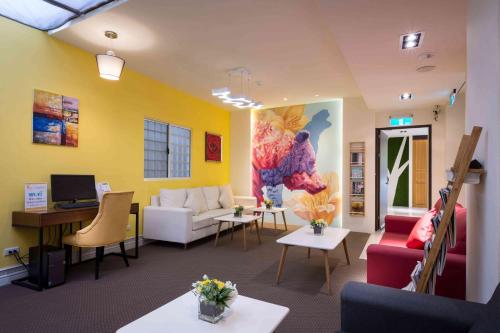 a living room with a couch and a table at 衿后禾居民生館 Good Hotel Minsheng in Kaohsiung