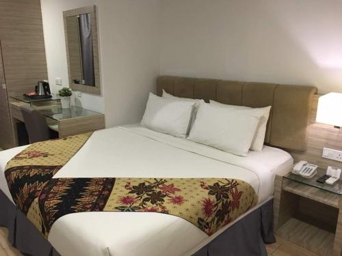 a bed in a hotel room with a phone on it at NU Hotel @ KL Sentral in Kuala Lumpur