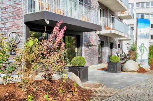 a building with plants in front of a building at Mondrian Suites Berlin am Checkpoint Charlie in Berlin