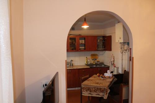 einen Torbogen, der in eine Küche mit einem Tisch führt in der Unterkunft Super Location in Yerevan