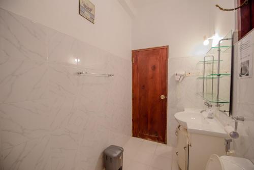 a white bathroom with a toilet and a sink at Muhsin Villa - Galle Fort in Galle