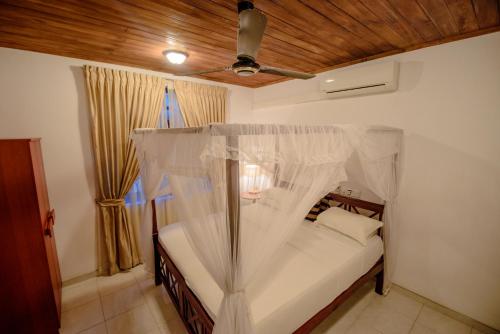 a bedroom with a bed with a mosquito net at Muhsin Villa - Galle Fort in Galle