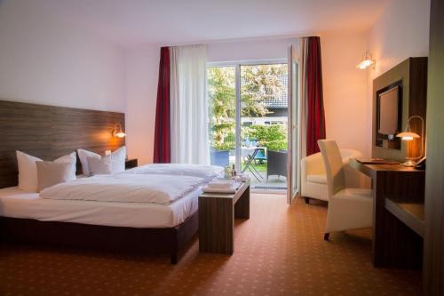 une chambre d'hôtel avec un lit et une fenêtre dans l'établissement Hotel & Restaurant Waldschlösschen, à Kyritz