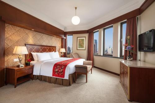 Postel nebo postele na pokoji v ubytování Jin Jiang Park Hotel