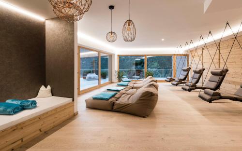 Tuberis Nature & Spa Resort في توبريه: غرفة معيشة كبيرة مع أريكة وكراسي