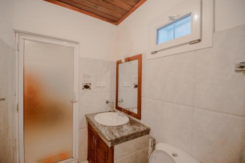 a bathroom with a sink and a toilet and a window at Muhsin Villa - Galle Fort in Galle
