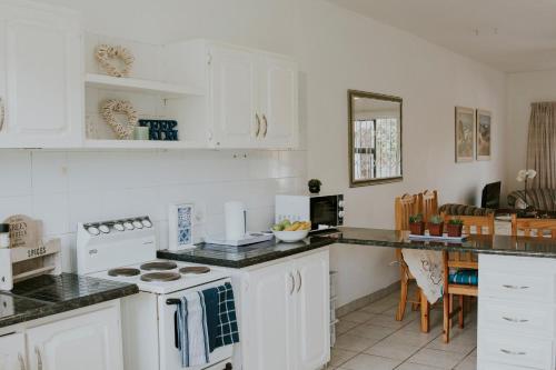 a kitchen with white cabinets and a counter top at Shelly Beach, Villa Albatross 2 in Shelly Beach