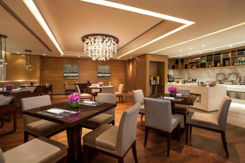 a dining room with tables and chairs and a chandelier at Ascott IFC Guangzhou - Free Shuttle Bus For Canton Fair in Guangzhou