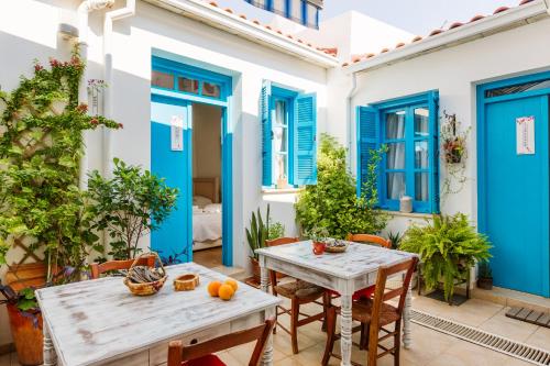 un patio con mesas, sillas y puertas azules en Cypriot Swallow Boutique Hotel, en Lefkosa Turk
