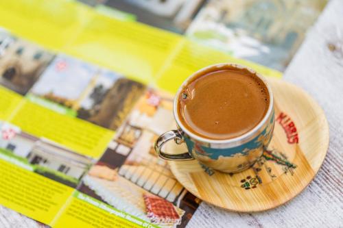 a cup of coffee sitting on a plate on a table at Cypriot Swallow Boutique Hotel in North Nicosia