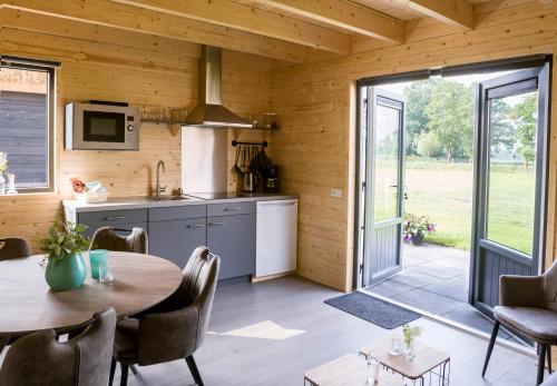 a kitchen and dining room with a table at Camping Nieuw Romalo in Voorthuizen