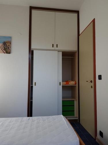 a bedroom with a white bed and a closet at Adriella apartments in Bibione