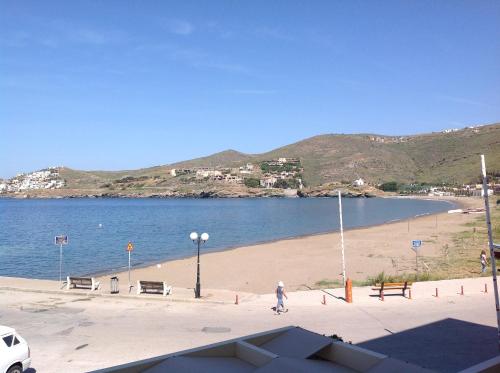 a person walking on a beach next to the water at Hotel Karthea in Korissia