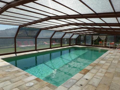 an indoor swimming pool with an open roof at Can Mahola in Beuda