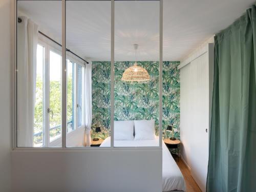 a room with a window and a bed and a mirror at Appartements Le Berliet - Montplaisir in Lyon